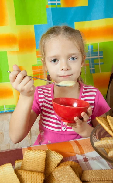 Dziewczynka jedzenie deser mleka — Zdjęcie stockowe