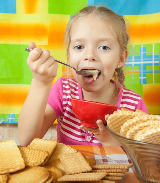 Little girl eating milk dessert — Stock Photo, Image