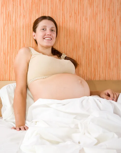 Mujer embarazada sentada en el sofá — Foto de Stock