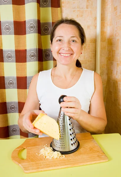 Donna matura grattugia formaggio — Foto Stock