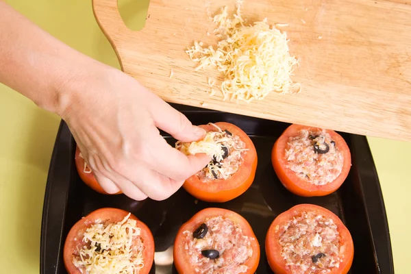 Cozinheiro adiciona queijo ao tomate recheado — Fotografia de Stock