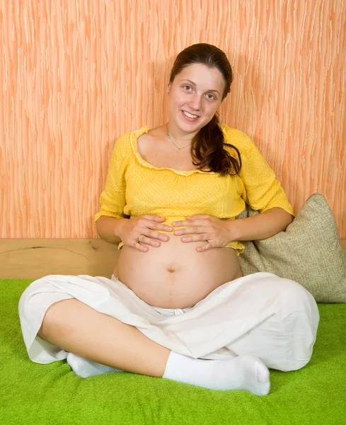 Kanepede oturan hamile kadın. — Stok fotoğraf
