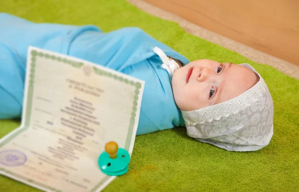 Newborn baby with certificate of birth document