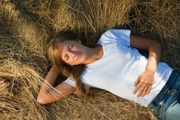 Девочка лежит на соломе — стоковое фото