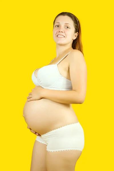 임신한 여자는 그녀를 노란색 — 스톡 사진