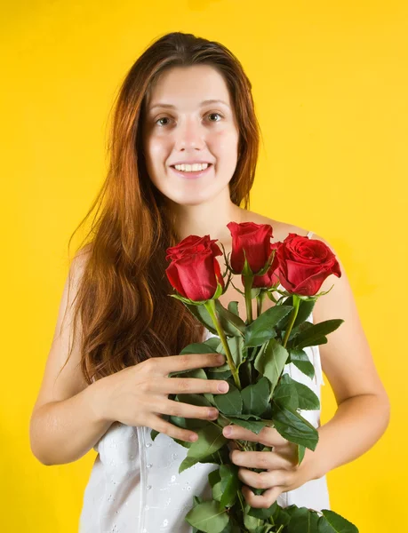 Chica con rosas sobre amarillo —  Fotos de Stock