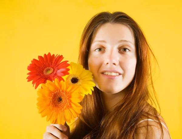 Κορίτσι με λουλούδια πάνω από το κίτρινο — Φωτογραφία Αρχείου