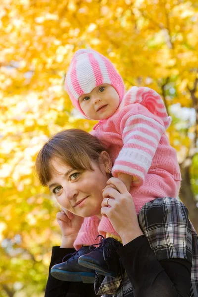Mãe com seu bebê contra o outono — Fotografia de Stock