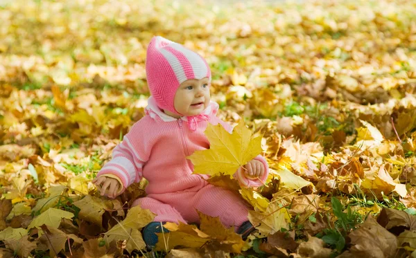 Bébé en feuilles d'automne jaunes — Photo