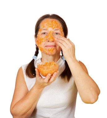 Mature woman making bio cosmetic pack from carrot, oatmeal and egg yolk clipart