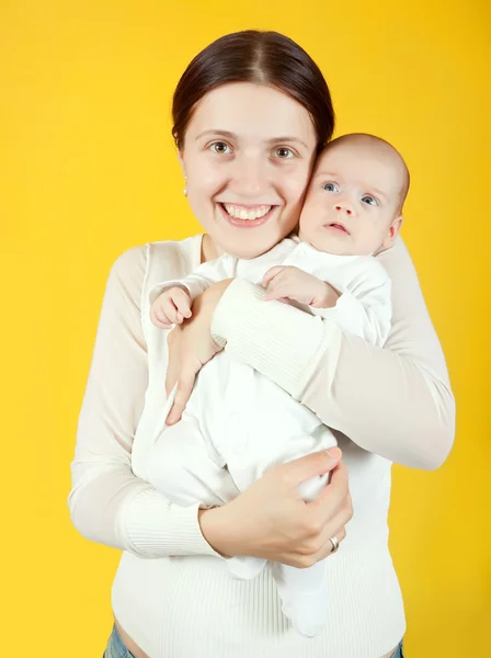 Matka Dítětem Nad Žlutým Pozadím — Stock fotografie