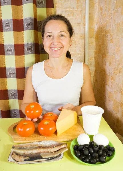 Женщина с ингредиентами для фаршированного томатного салата — стоковое фото