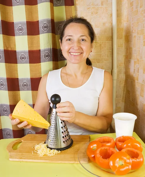 Donna grattugia formaggio nella sua cucina — Foto Stock