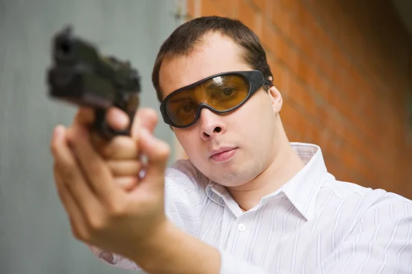 Человек с пистолетом у стены — стоковое фото
