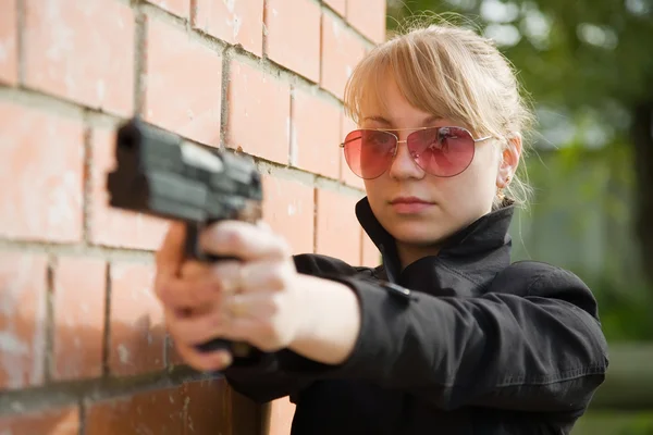 Young Woman Aiming Black Gun Brick Wall — Stock Photo, Image