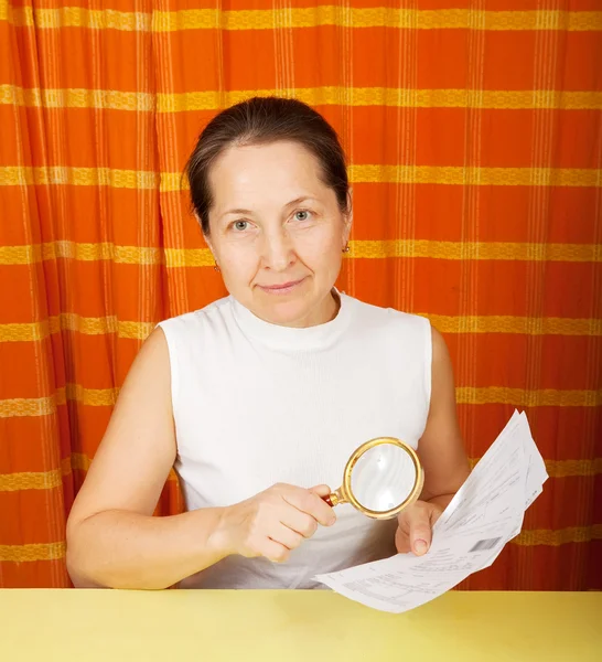 Mature woman looking at utility bills — Stock Photo, Image