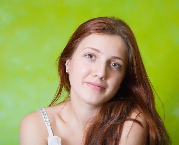 緑の背景の上の長い髪の少女の肖像画 — ストック写真