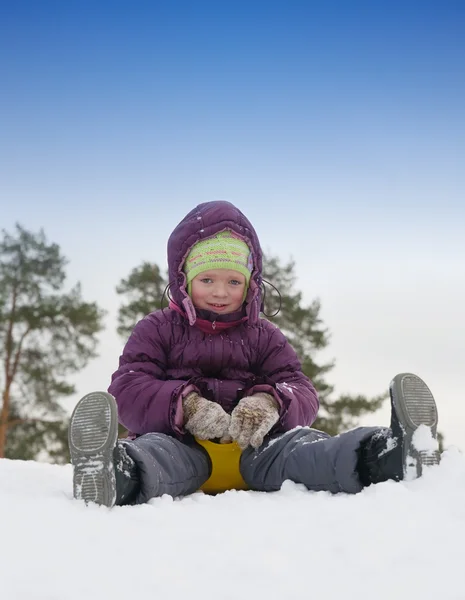 Klein kind glijden in de sneeuw — Stockfoto