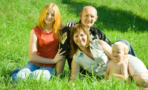 子供を持つ親は 公園で草の中を産む — ストック写真