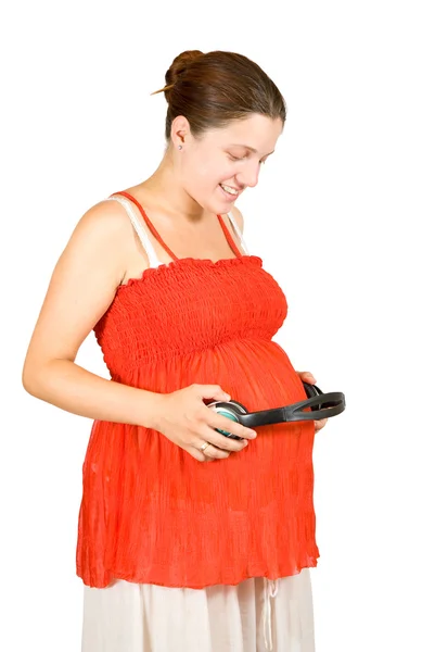 若い妊婦遊んでリラックス音楽赤ちゃんのおなかの上のヘッドフォンで — ストック写真