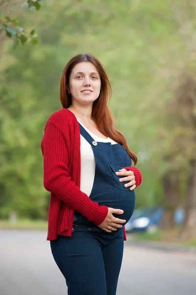 Gravid kvinna på sommaren gränd — Stockfoto