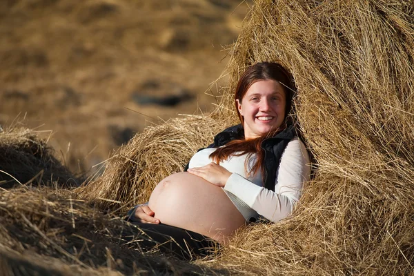 Mulher grávida descansando no feno — Fotografia de Stock