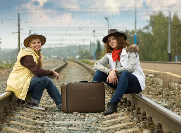 Mooie meisjes zitten op rail — Stockfoto