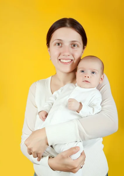 Mother Holding Young Baby Yellow Background — Stock Photo, Image