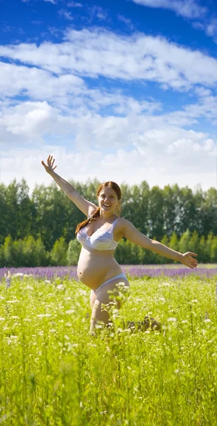 Mulher grávida correndo no prado — Fotografia de Stock