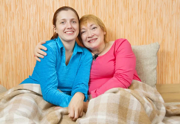 快乐的女人和她成人的女儿在家里的沙发上 — 图库照片