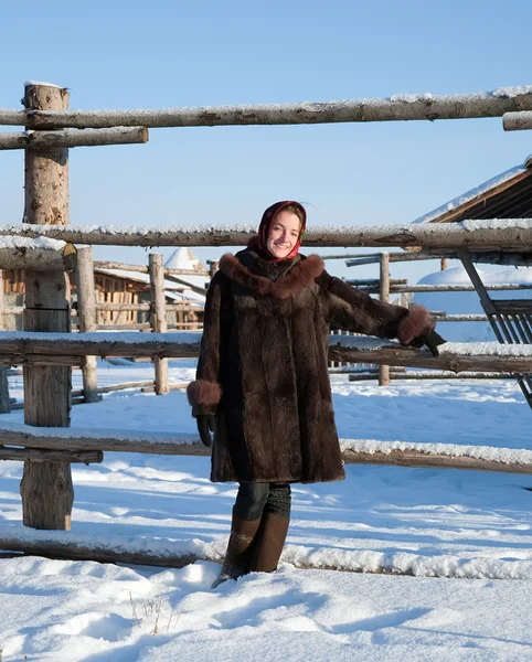 Девушка в шубе против зимней сельской местности — стоковое фото