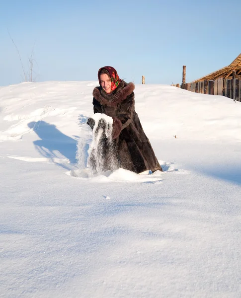 Girl in fur coat throwing snowflakes — Stok fotoğraf
