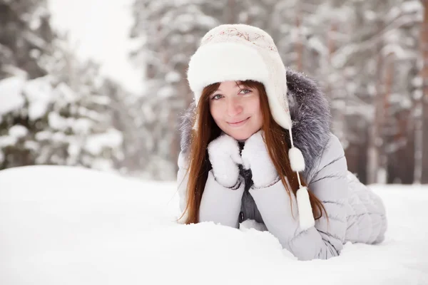 Молодая женщина лежит на снегу — стоковое фото