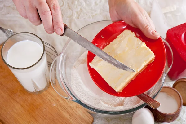 Ręce kucharza dodaje margaryny do ciasta — Zdjęcie stockowe