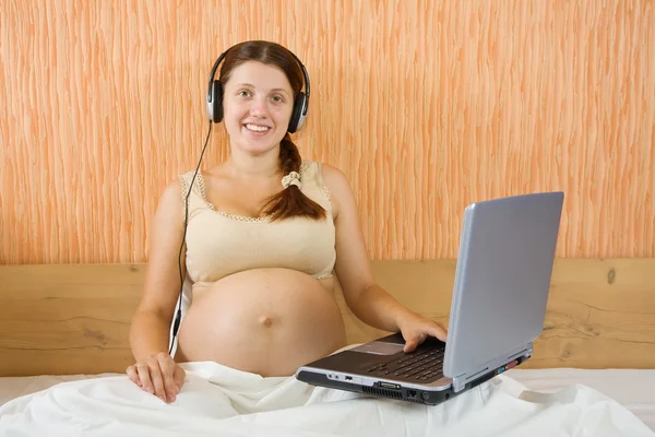 Gravid kvinna lyssna på musik — Stockfoto