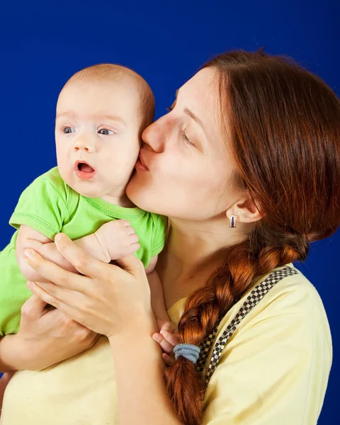 Мати цілує молоду дитину — стокове фото
