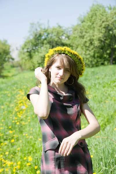 Girl in a chaplet against a meadow — Stock Photo, Image