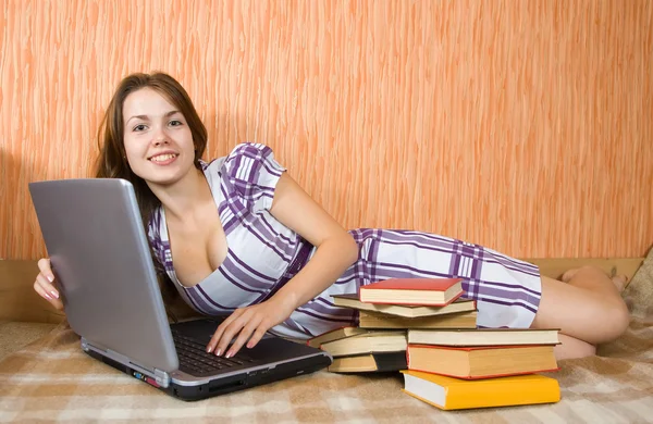 Flicka med bärbar dator och böcker — Stockfoto