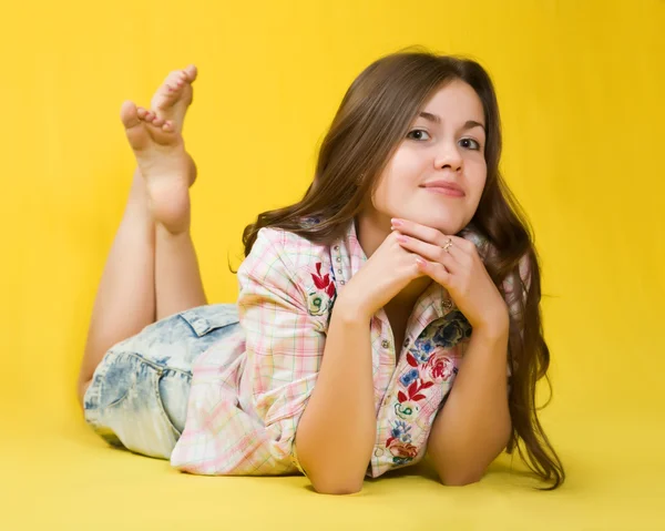Brunette meisje rust over geel — Stockfoto