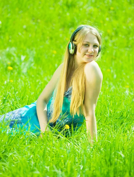 女の子の牧草地で音楽を聴く — ストック写真
