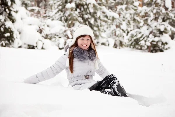 Счастливая девушка сидит на снегу — стоковое фото
