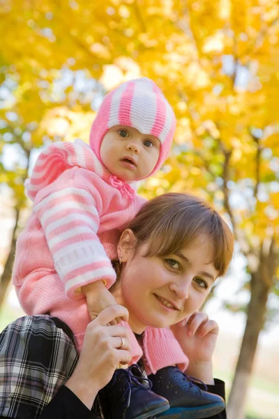 Mamma med barn mot hösten natur — Stockfoto