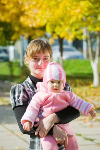 Moeder met kleine baby in de herfst — Stockfoto