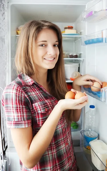 Refrigerato에 계란을 넣어 소녀 — 스톡 사진