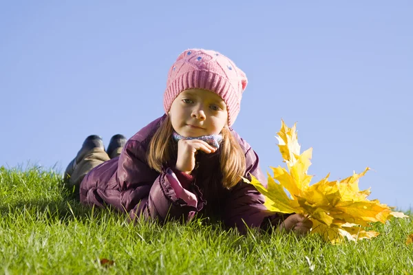 Dívka na trávě proti obloze — Stock fotografie