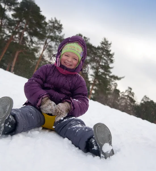 Criança deslizando na neve — Fotografia de Stock