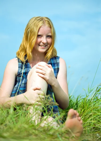 Girl sitting in meadow grass — Stock Photo, Image