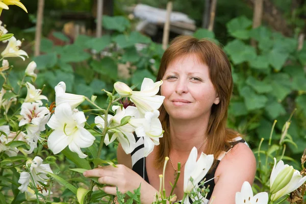 Kobieta z lilią w swoim ogrodzie — Zdjęcie stockowe