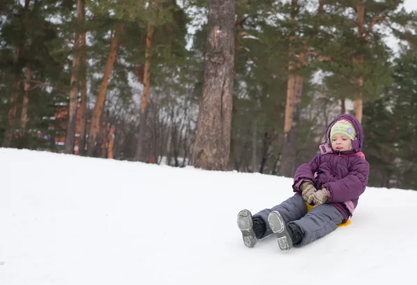 Child sliding in the snow Stock Photo