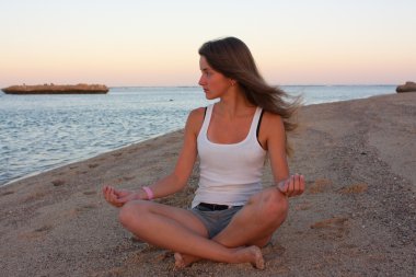 Deniz kenarında yoga yaparken kız